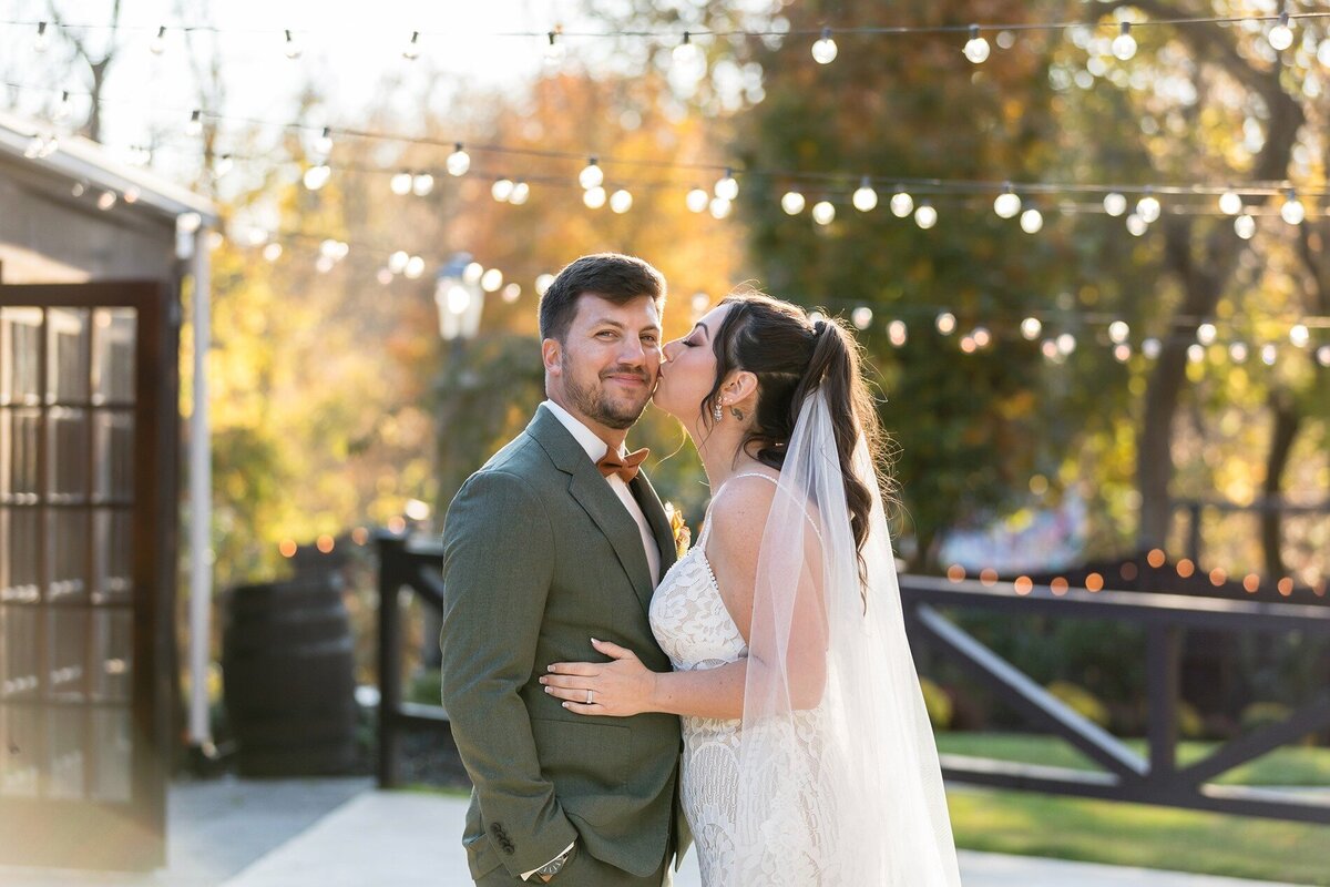 bride-kissing-groom-cheek-hamilton-manor-patio