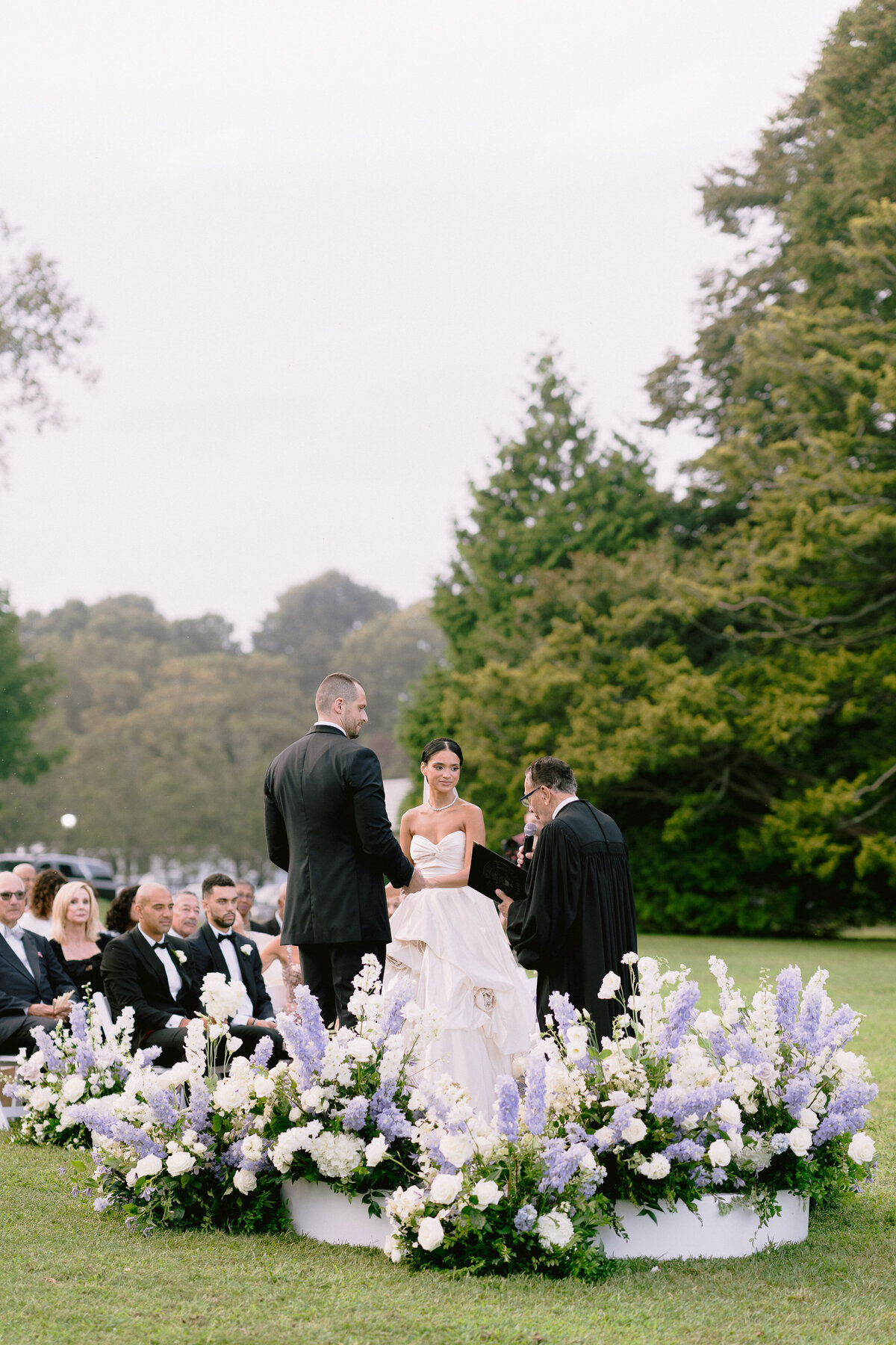 An outdoor wedding ceremony at Rosecliff mansion, with floral design by Stoneblossom