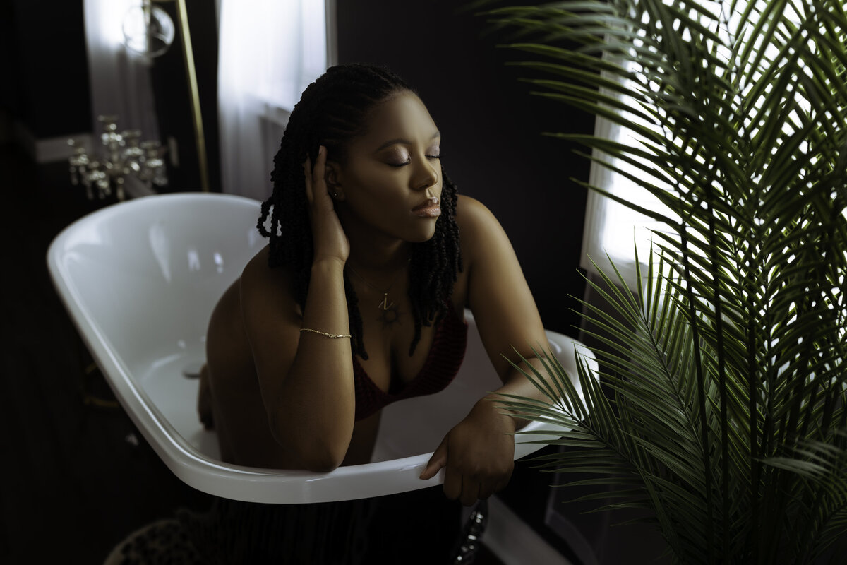 Boudoir Photographer, a woman in her underwear sits in an empty bathtub