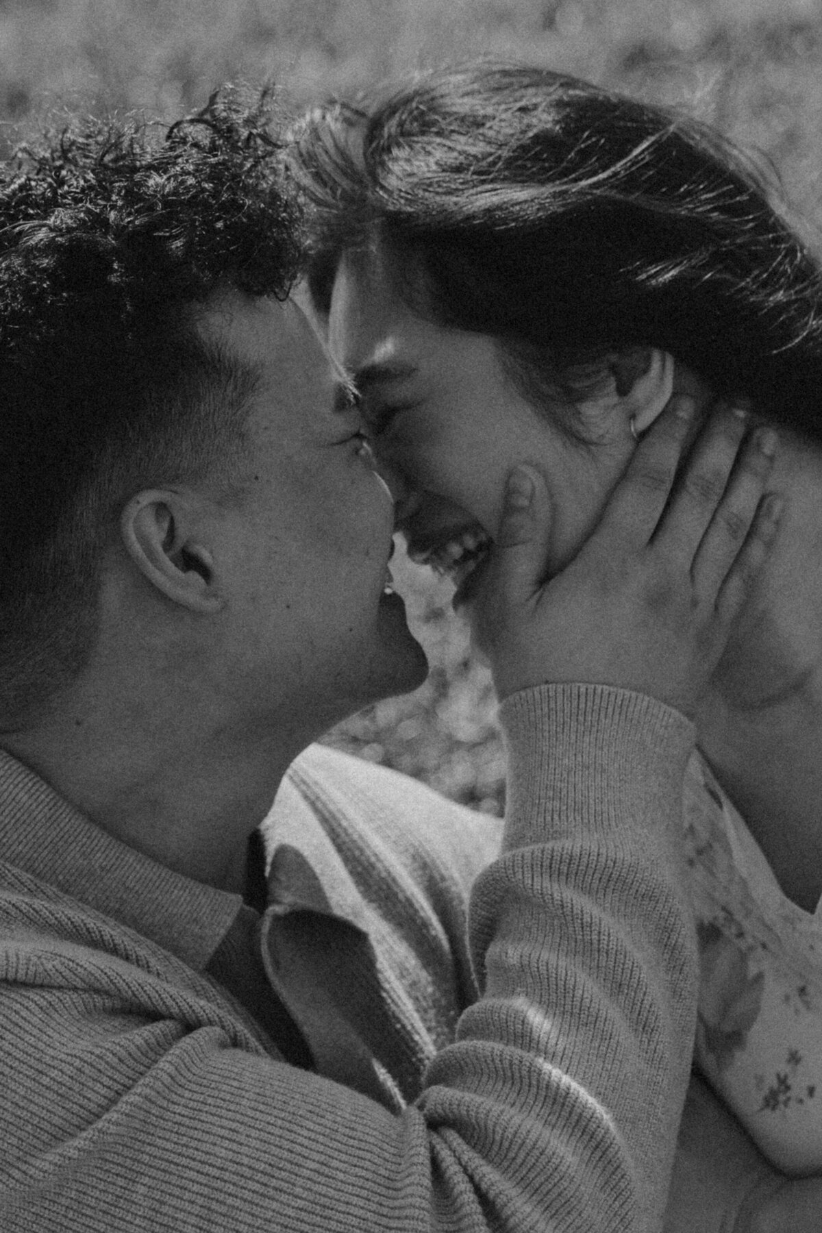 Close-Up Black and White Engagement Photo of Couple Laughing and Holding Each Other