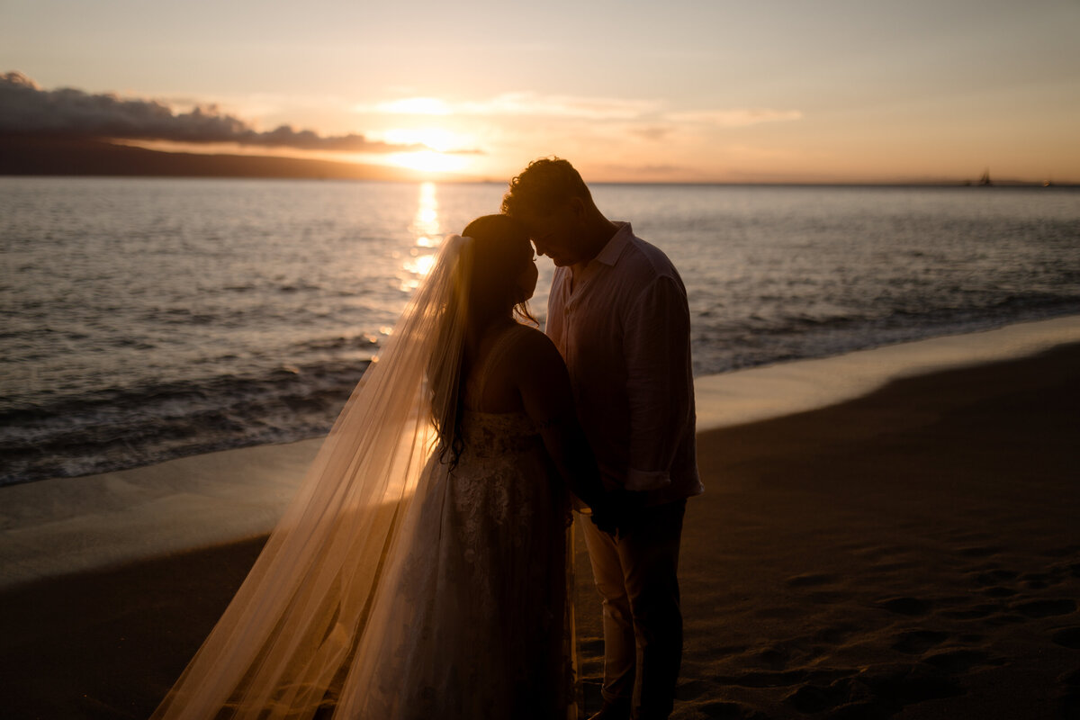 Bride and groom on beach at sunset