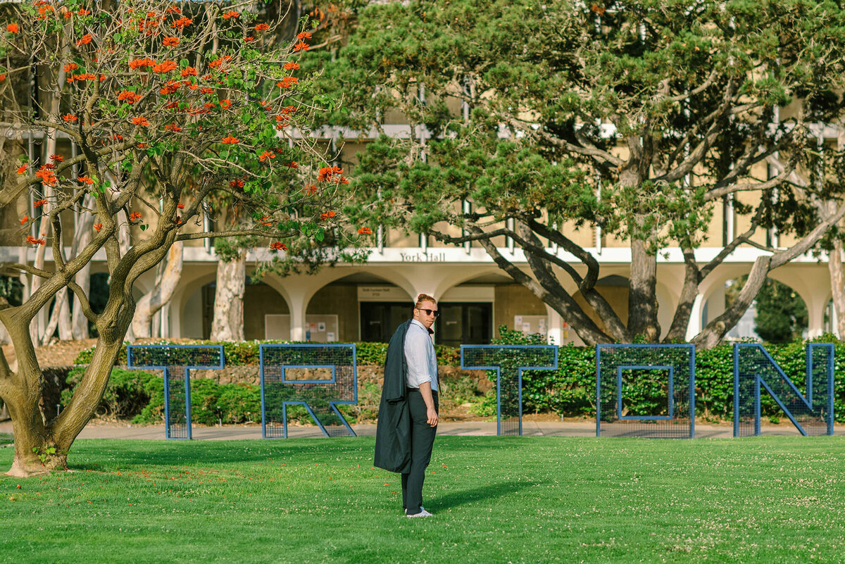 Cap and gown photos at UCSD - standing in front of the Triton sign near Revelle college