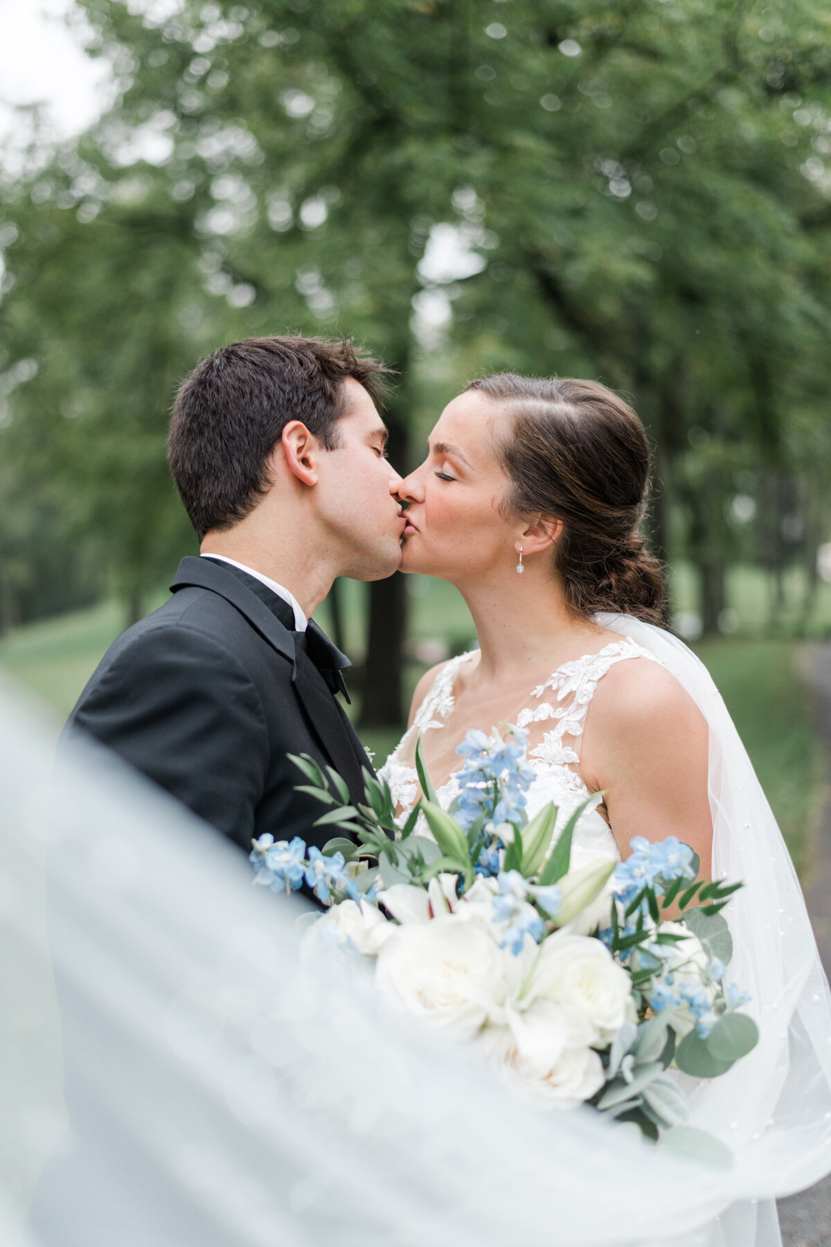 Bride and groom share a kiss with the veil in the foreground