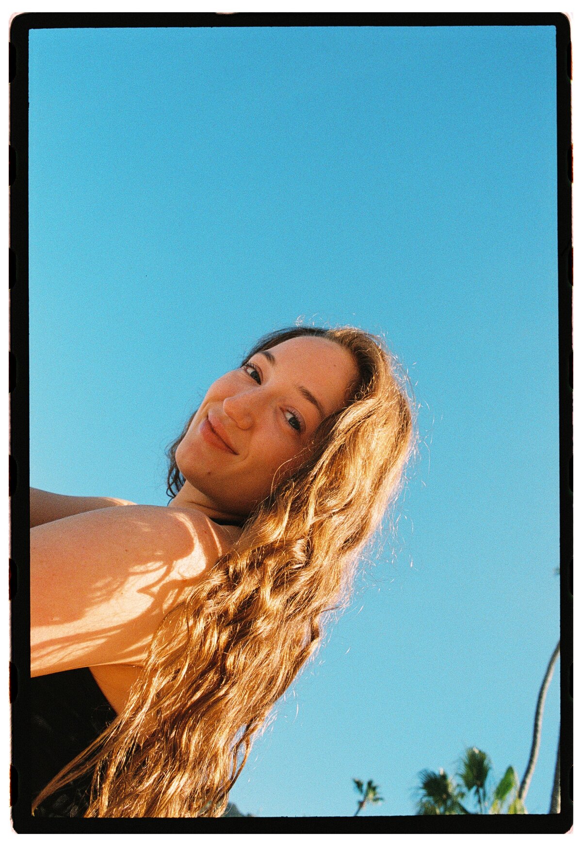 Portrait with sky backdrop, captured on film by Kate Winters Photography, showcasing an authentic and candid moment in Carmel, California.