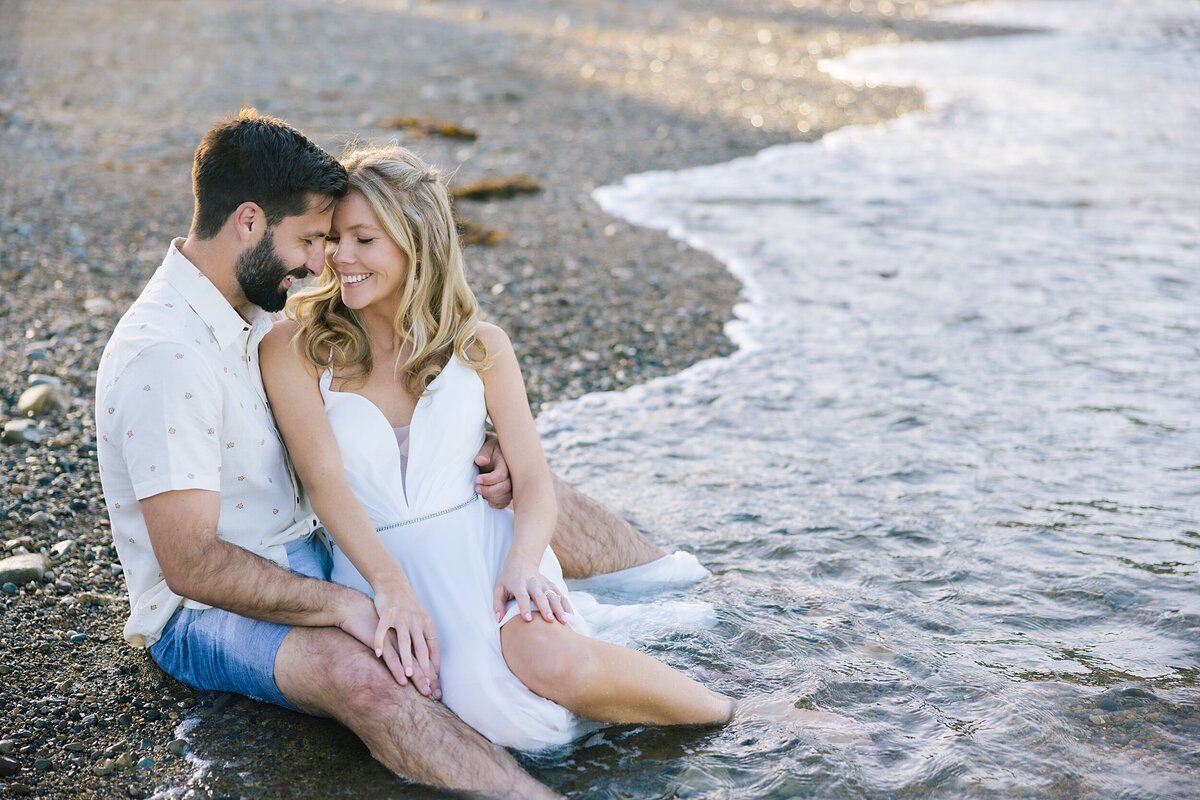 A bride and groom  sit on the beach for their Catalina Island elopement
