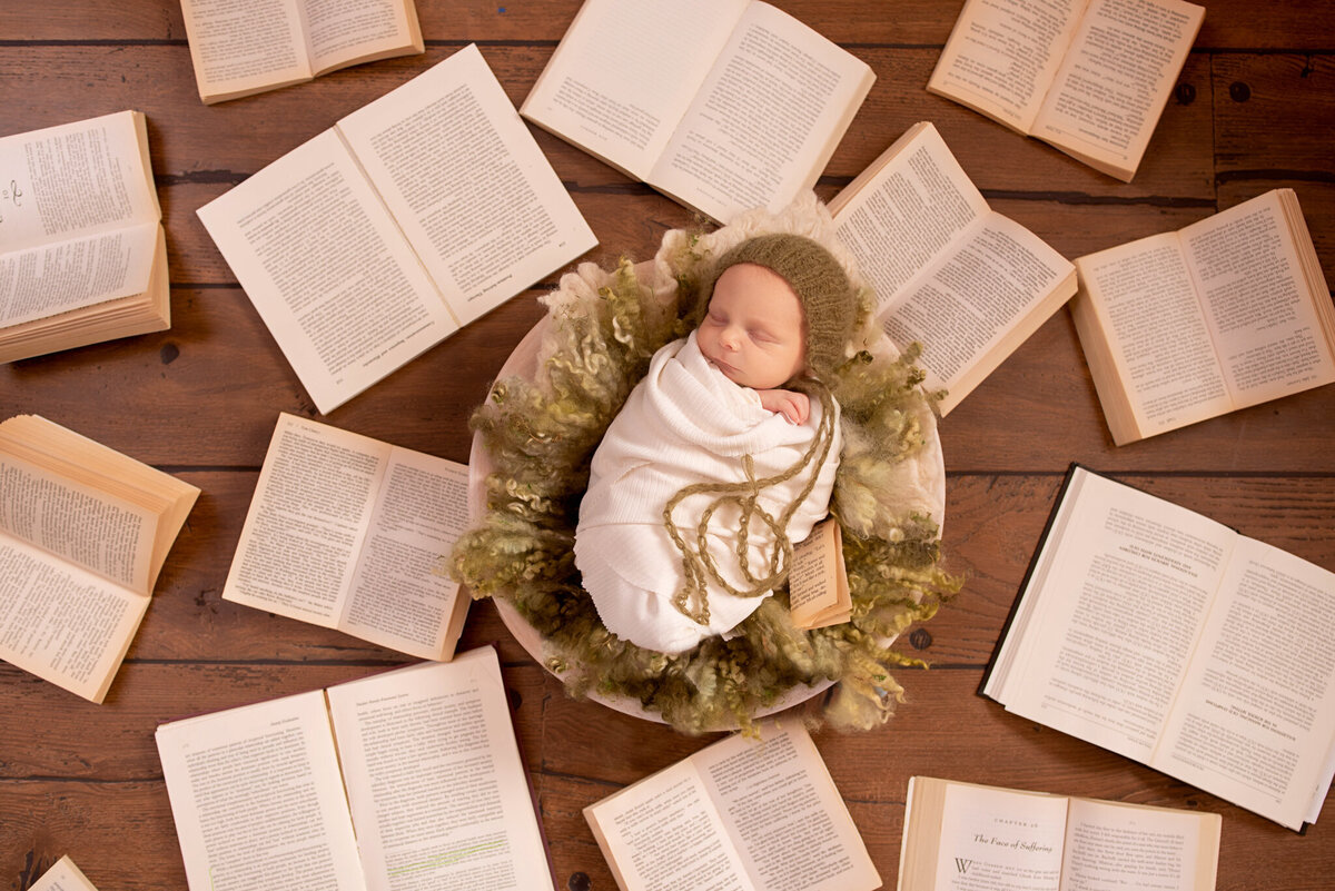 Newborn surrounded by storybooks in a cozy literary-themed setup, captured in Overland Park, Kansas. Ideal for families seeking creative and themed newborn photography in the Kansas City area.