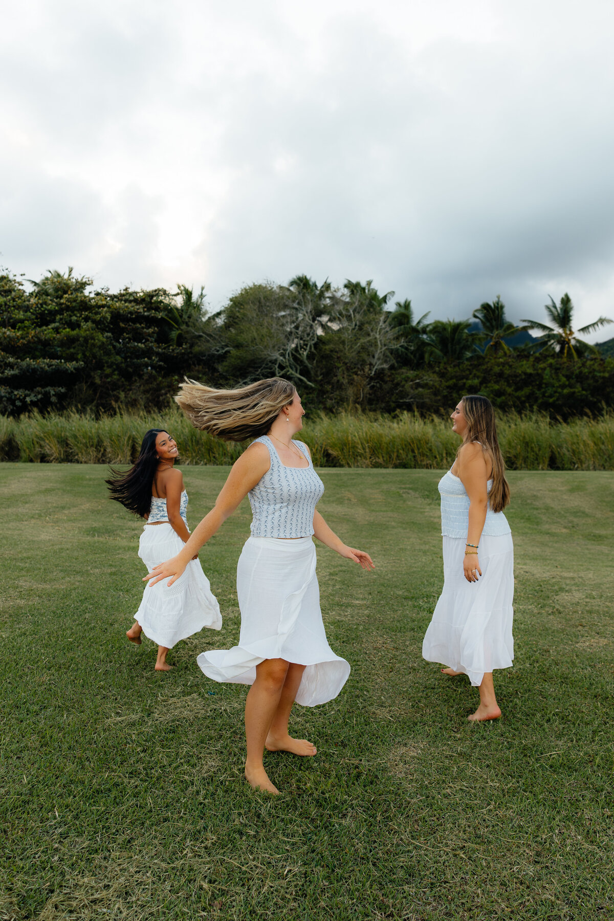 Three best friends twirling around during their Hawaiian photoshoot