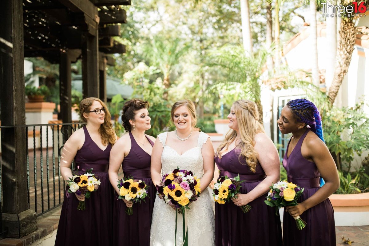 Bride poses with her Bridesmaids wearing purple dresses