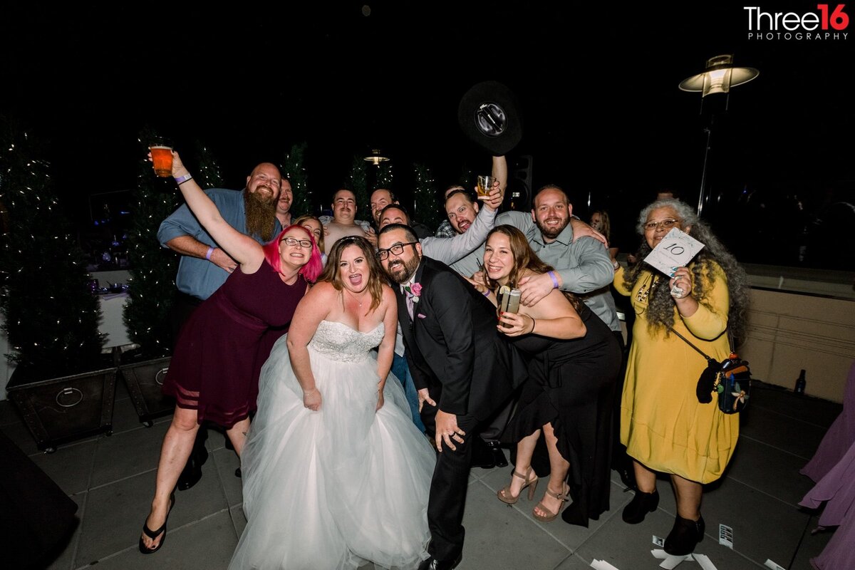 Bride and Groom pose for a crazy fun photo with wedding guests on the dance floor