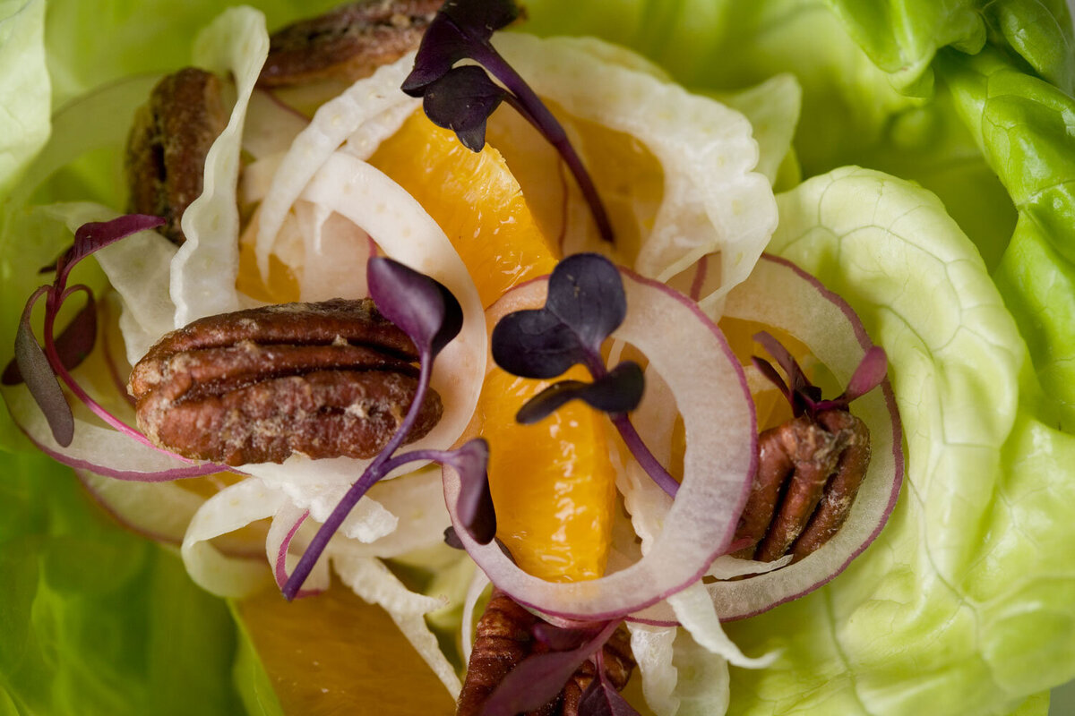 Salad with orange slices, pecans, and microgreens