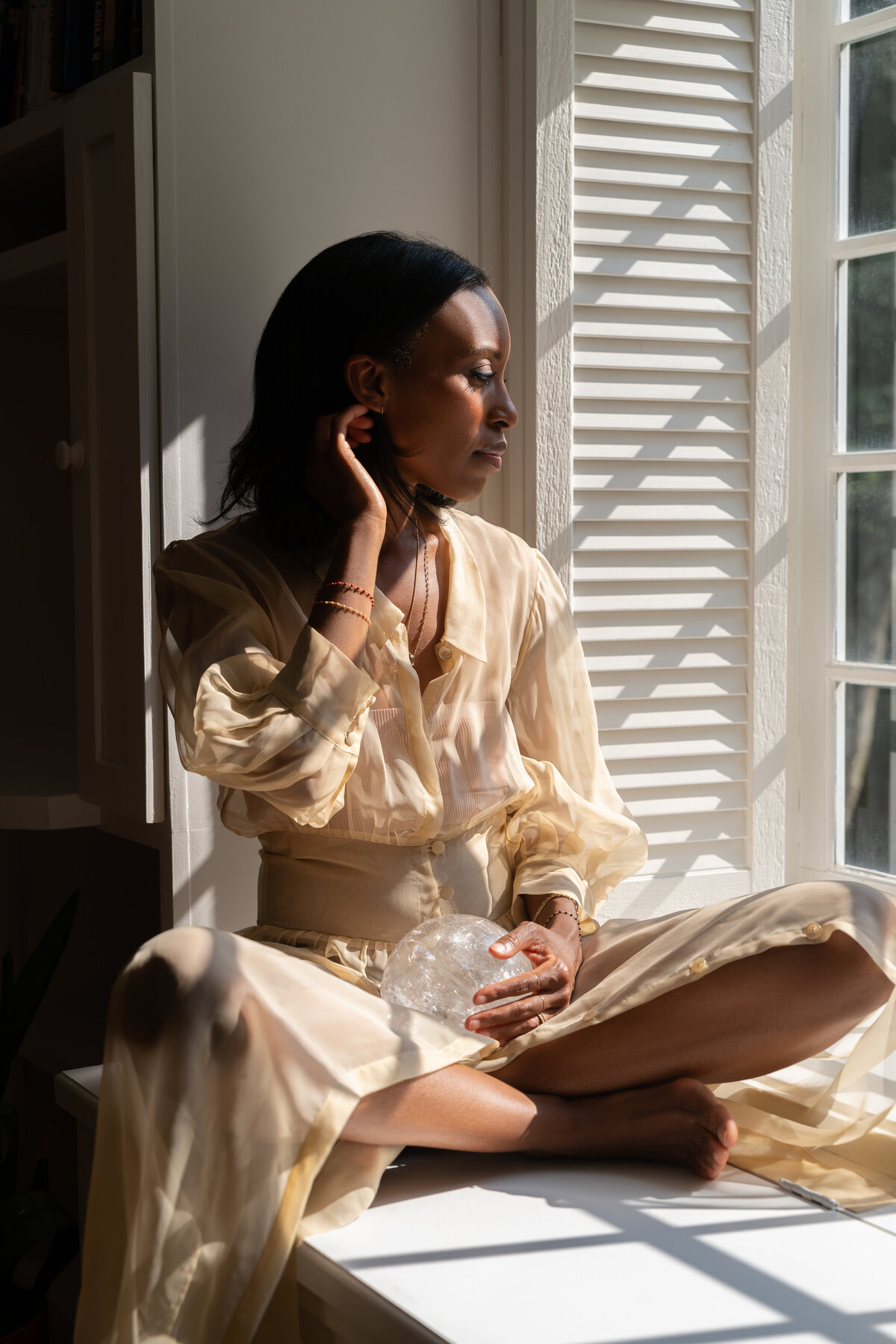 portrait of woman in window seat with strong shadows