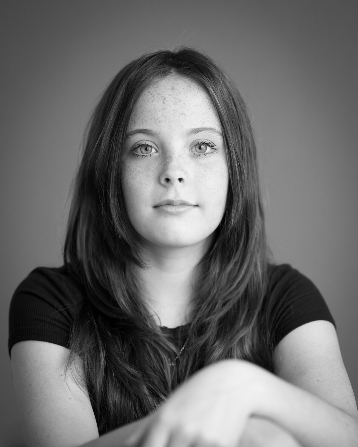 black and white portrait headshot of girl with confidence in  her eyes, looking at camera