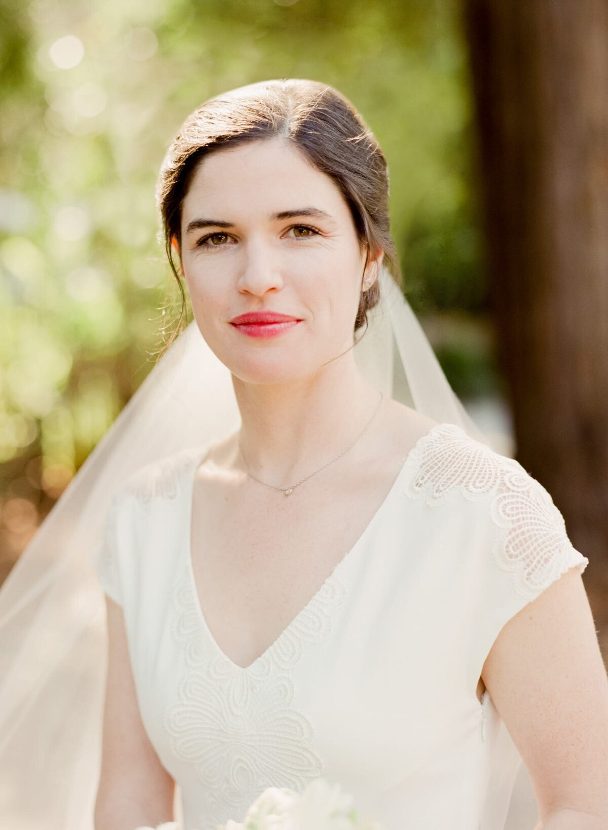 Bride of the wedding poses in her half-sleeve wedding dress with a veil on her head.