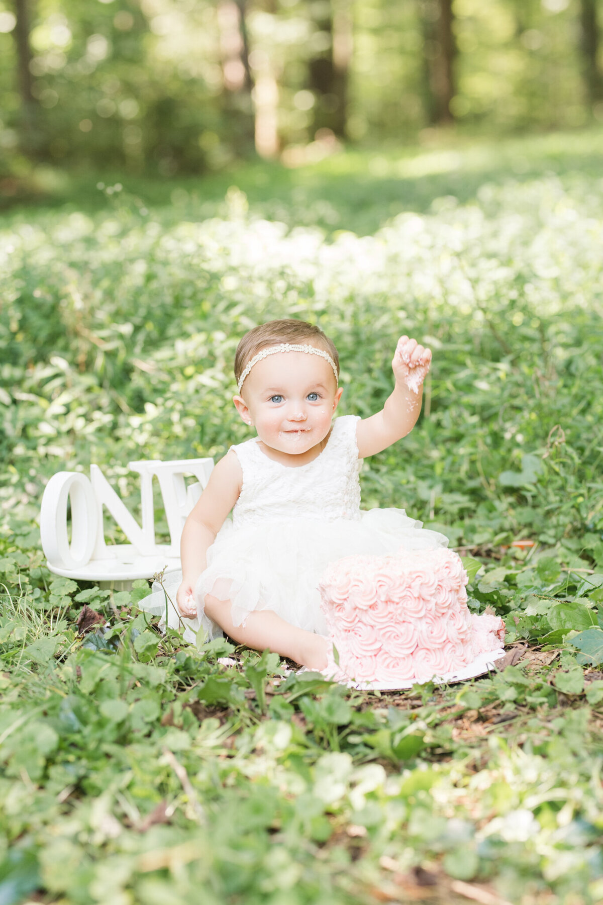 baby girl eating cake at a park in statesville nc- outdoor cakesmash