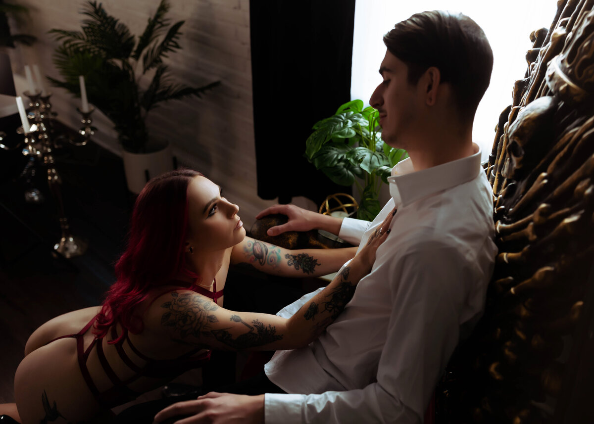 couples boudoir photo of woman kneeling in front of husband in lingerie elkridge