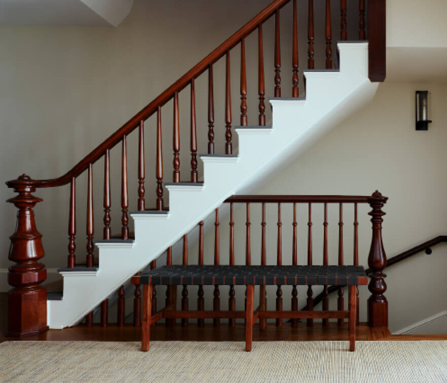 Boston Brownstone Renovation restores original stairs with original newel posts, heightened spindles, fresh paint, and stained natural wood by Boston interior designers.