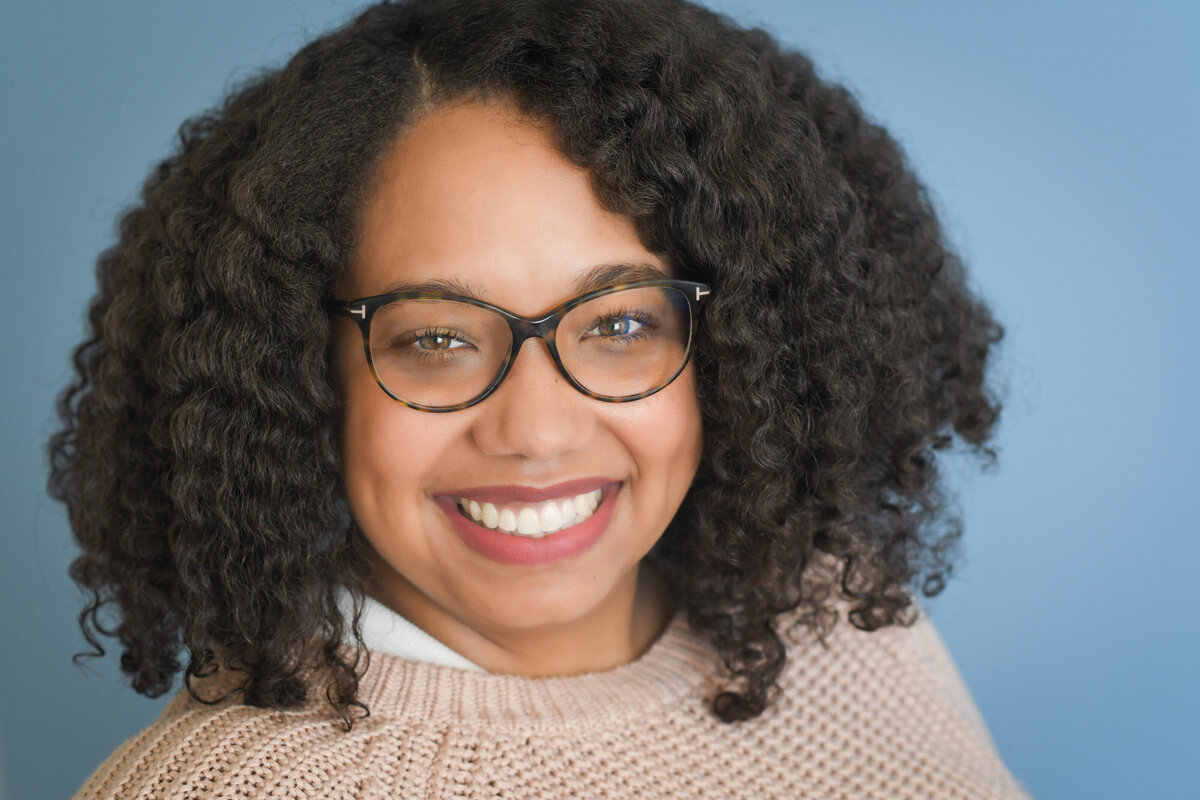 A woman with glasses smiling