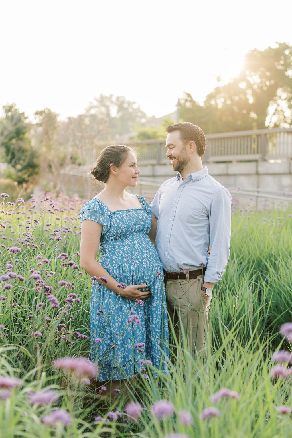 Pregnant wife looks at husband in a field of flowers outside the national mall