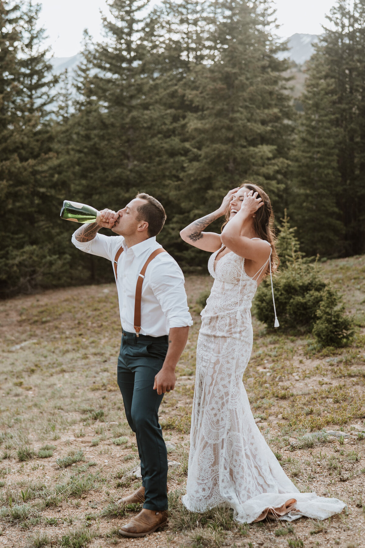 Bride and groom celebrating with champagne in forest after Hoosier Pass mountain elopement.