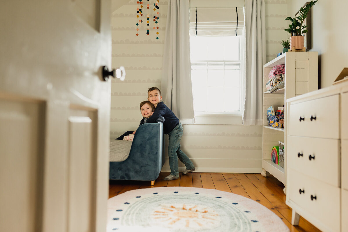 Two young children playing in bedroom.