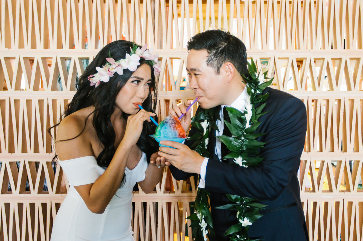 bride and groom sip on shave ice in Hawaii on their wedding day