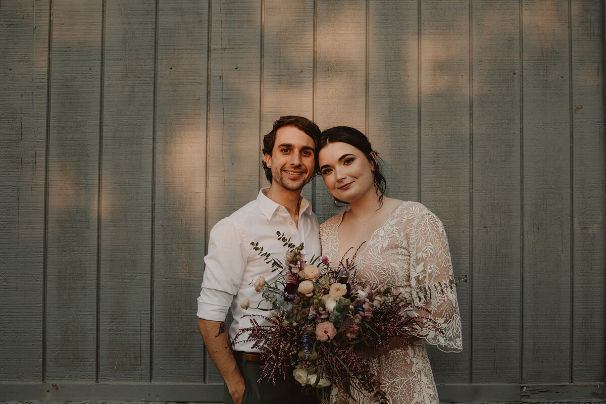 Newlyweds standing head to head smiling 