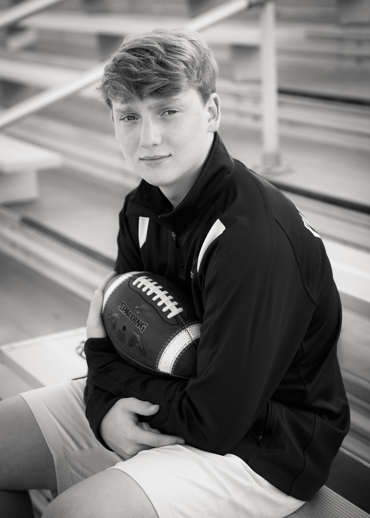 Black and white striking senior photo of a football play on bleachers in Penn Yan