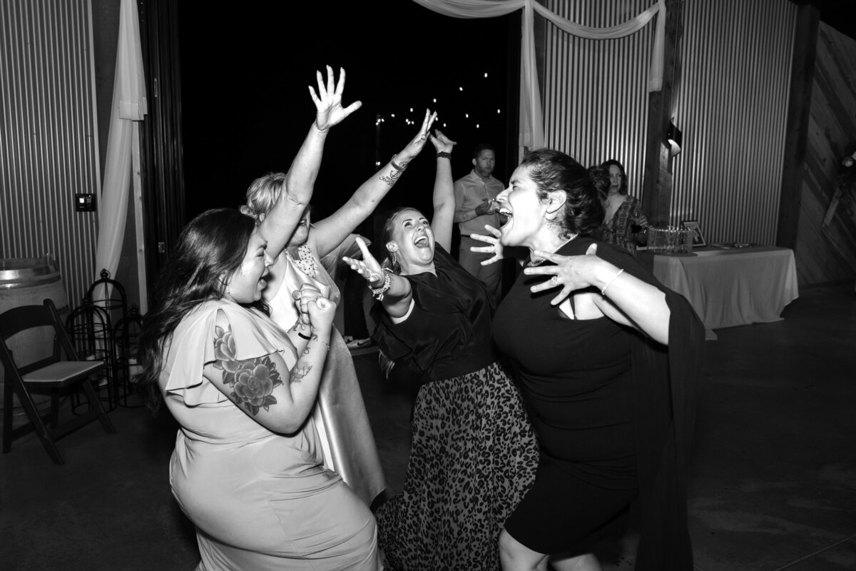 Shannon Lee, a Florida wedding photographer, captures guests in a joyful, animated moment on the dance floor, celebrating with laughter and enthusiasm.