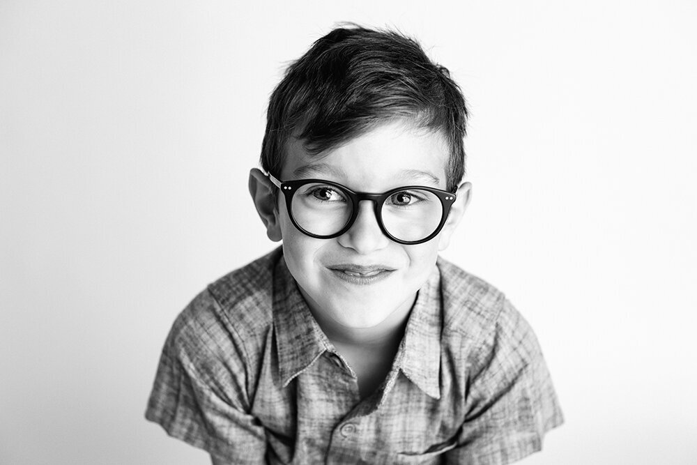 blackandwhiteboywithglassessmirk