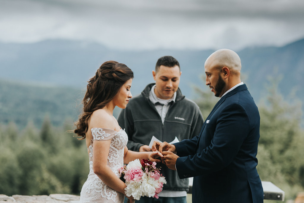 Bride and Groom exchange rings in an elopement ceremony on top of Mt. Rainier.