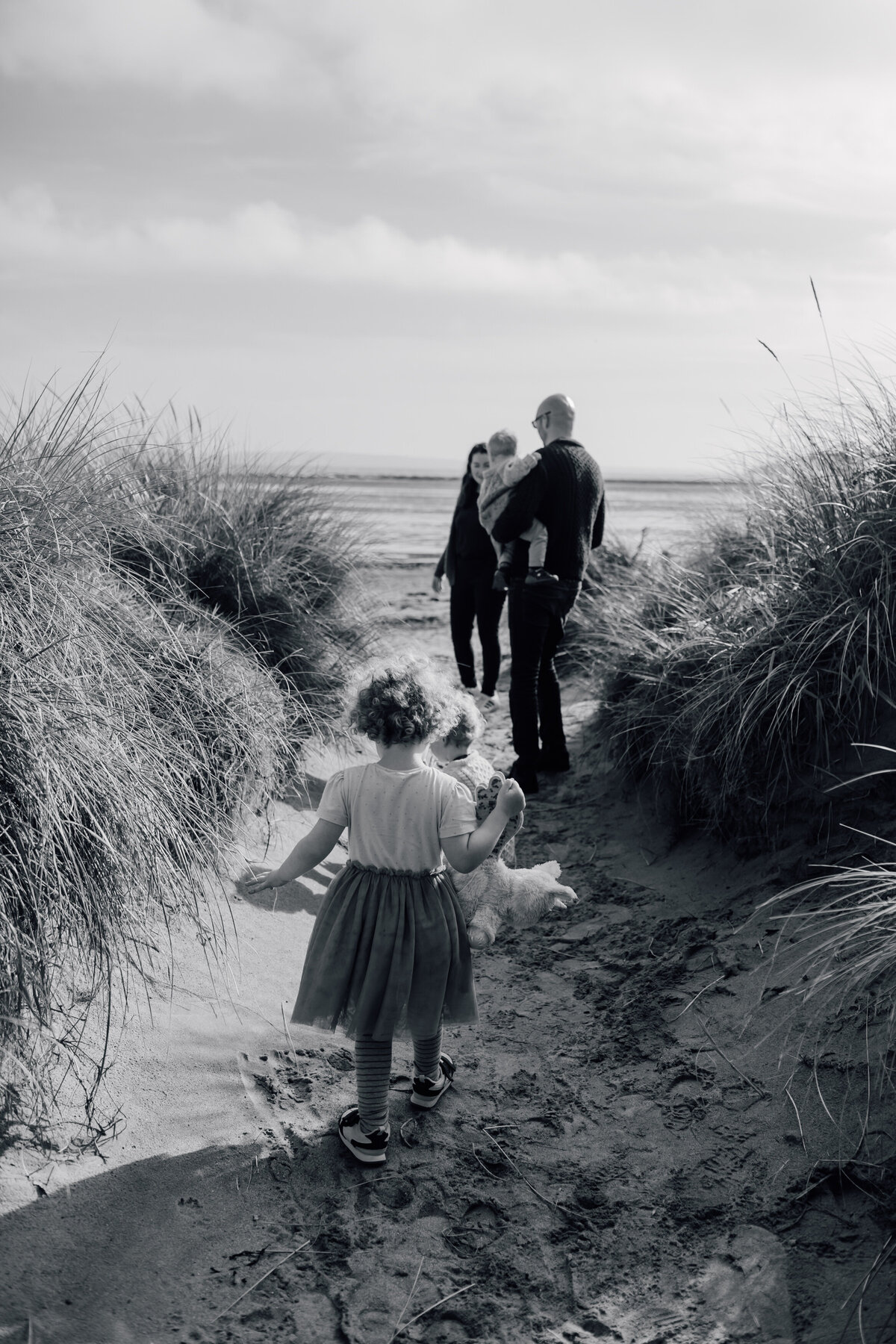 girl-running-on-to-beach-with-parents