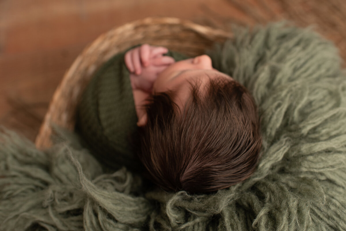 Top of baby boy's head, wrapped in green