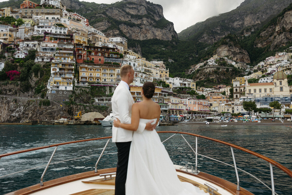 Bride and groom soaking in Positano Italy from their private yacht on their wedding day, photographed by Andrea-Marie Photography 