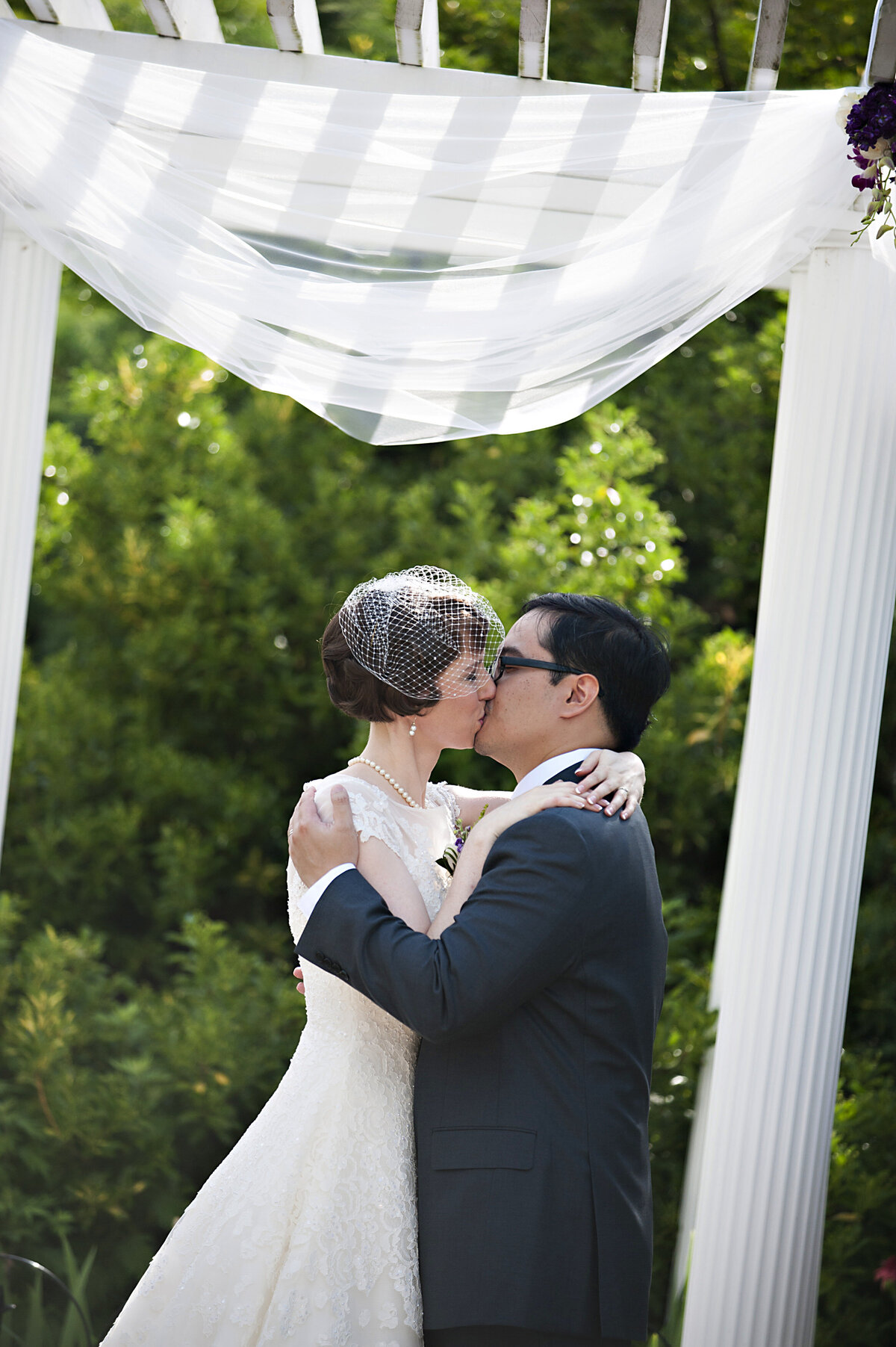 A couple during their first kiss at their wedding 