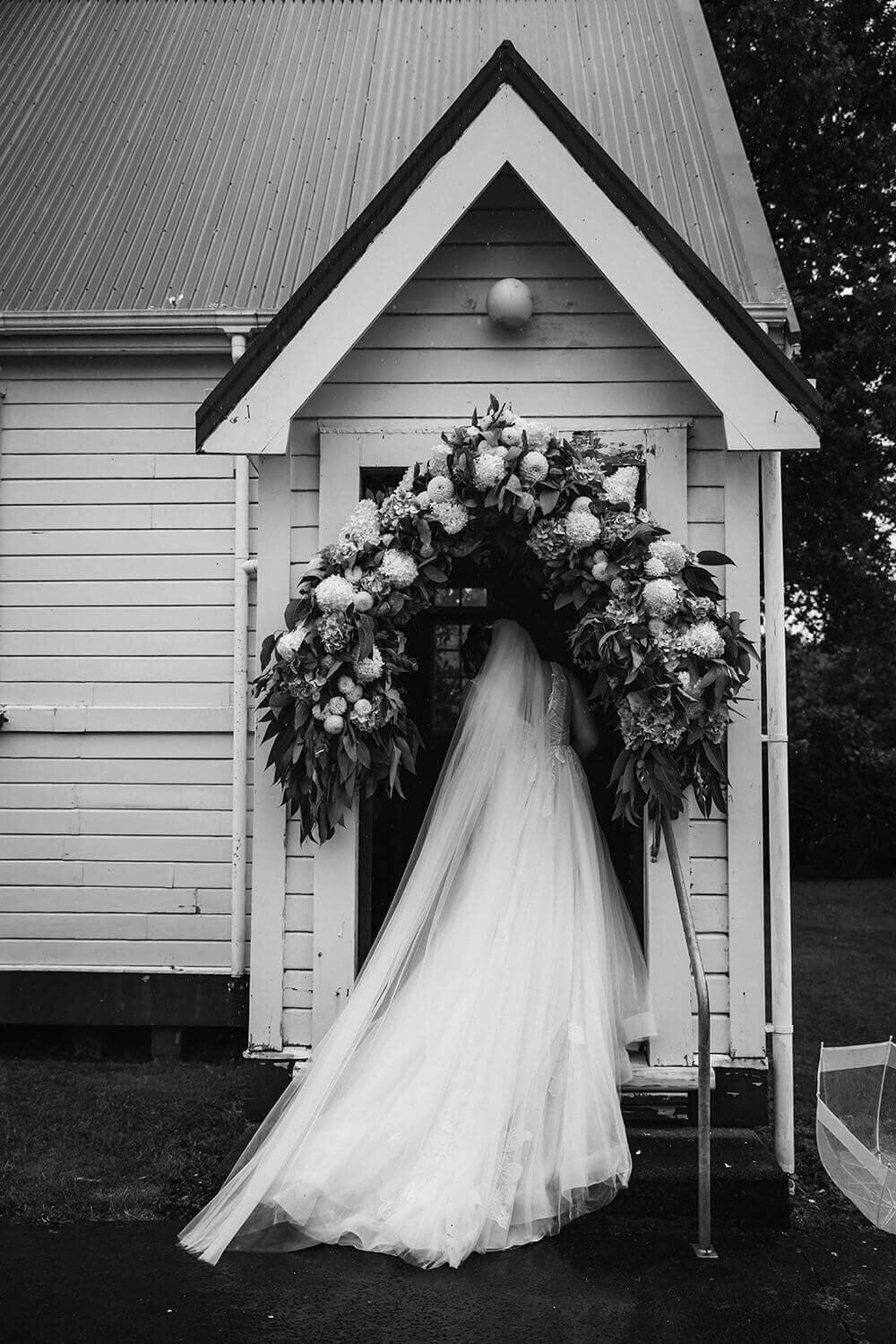 A bride walking into the church before the ceremony while wedding photographer aimee kelly photographs her