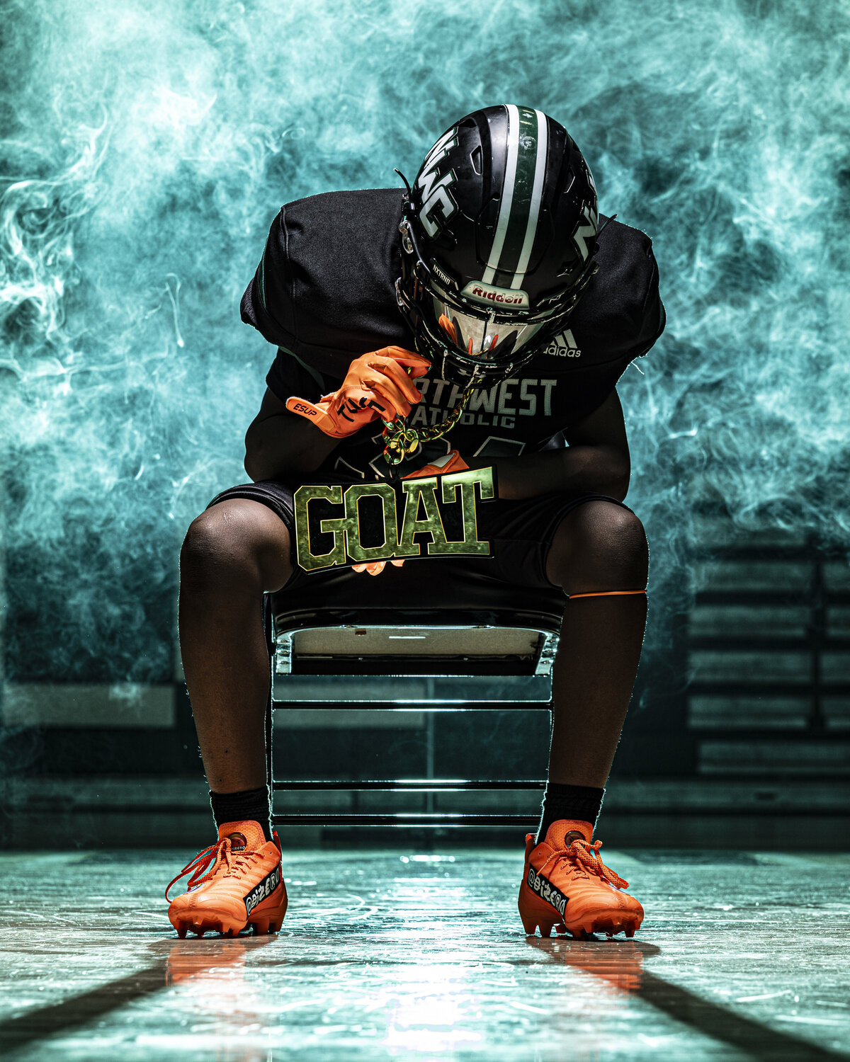 CT Photographer | Media Day Photos | Football Player sitting in chair holding a GOAT chain with green smoke in background. 