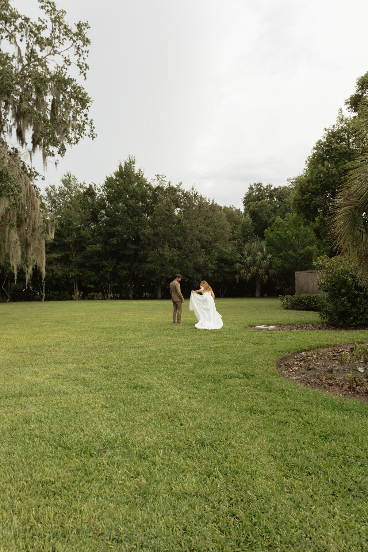 Romantic backyard wedding at The Palm Mansion in Umatilla, Florida with lush palm trees and floral arch