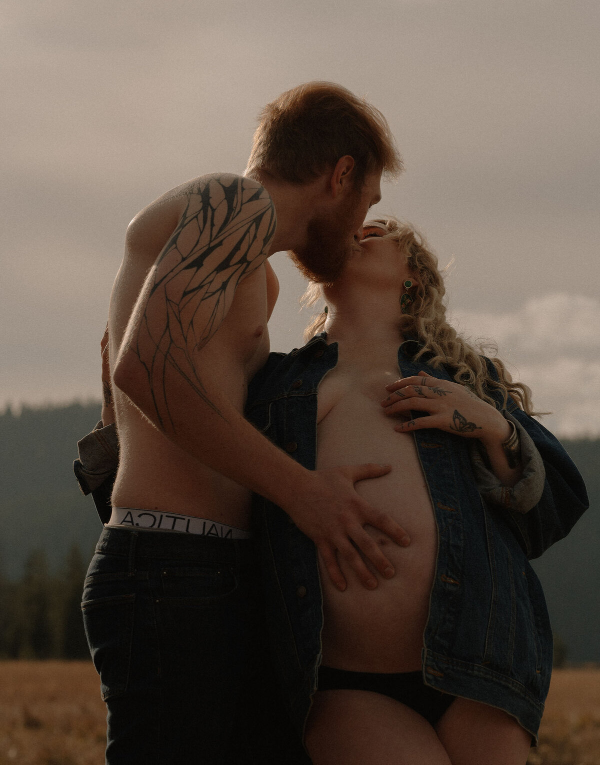 expecting parents kiss and share intimate moment during outdoor maternity photoshoot in Bend, Oregon