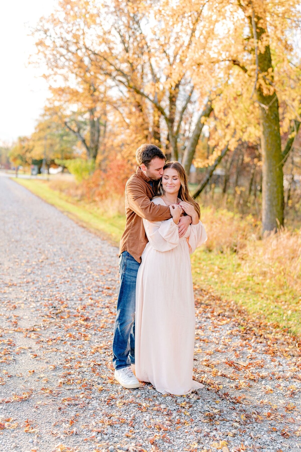 groom-kissing-bride-hugging-fall