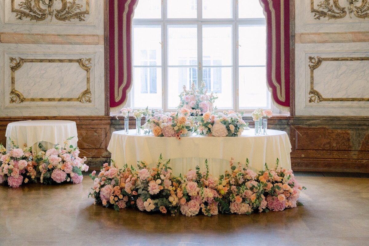 Sweetheart table surrounded by fresh flowers for an US destination wedding couple, designed by luxury wedding agency ÈCLAT Destination Weddings