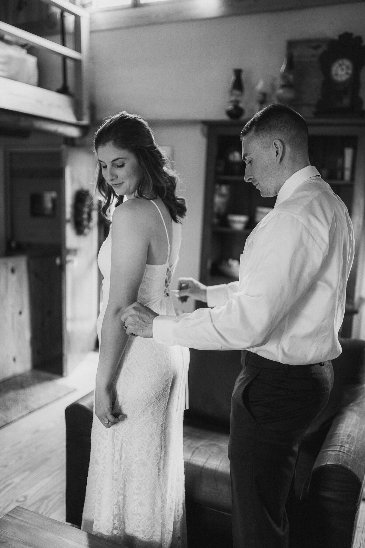 groom ties bride's dress