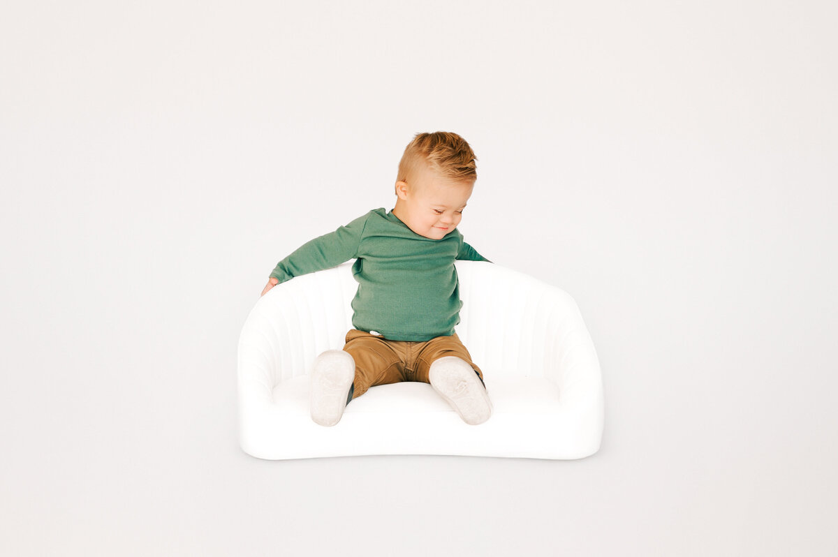 Springfield MO special needs kids photographer captures baby boy laughing at himself on couch