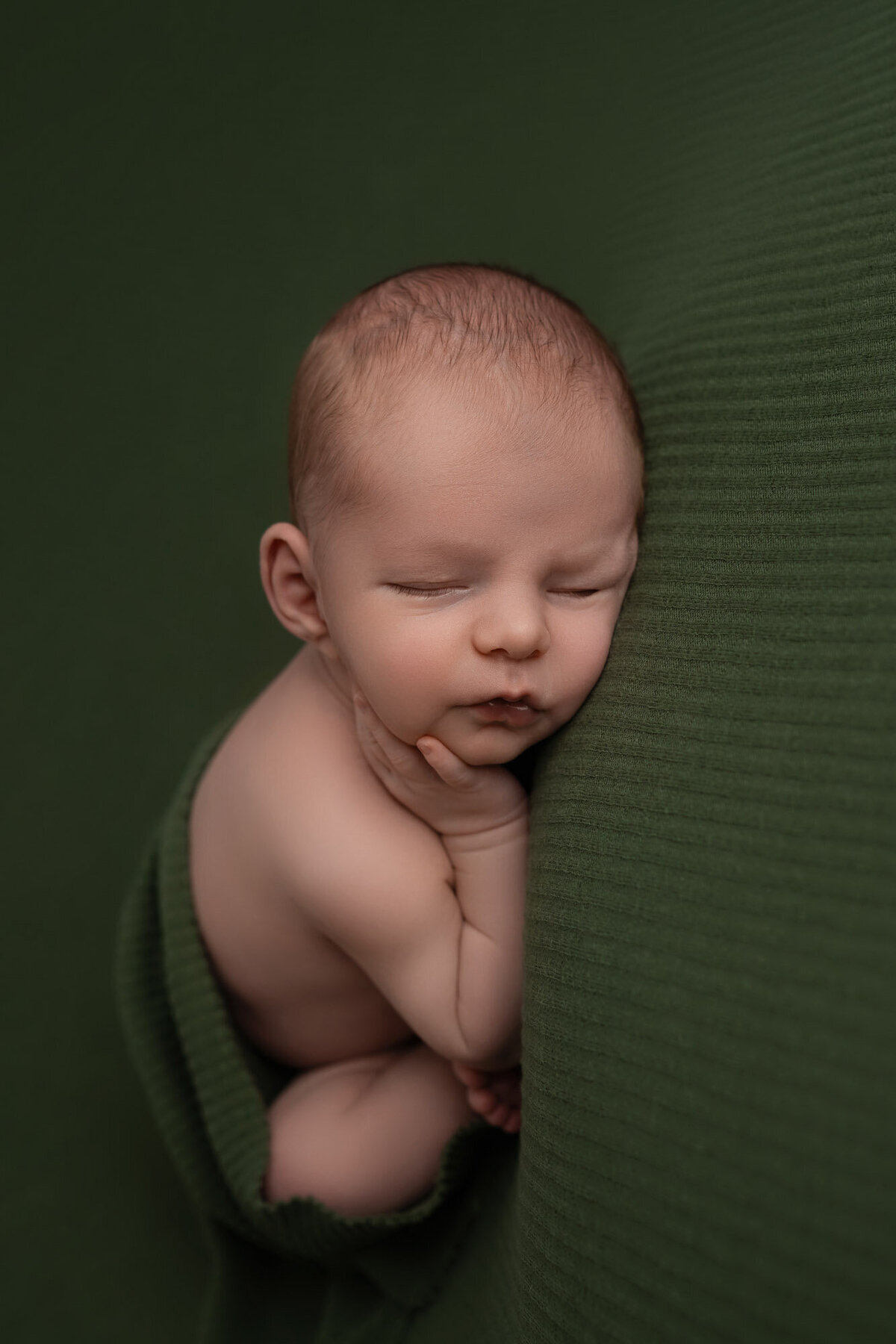 Newborn baby green blanket side pose Austin professional photographer