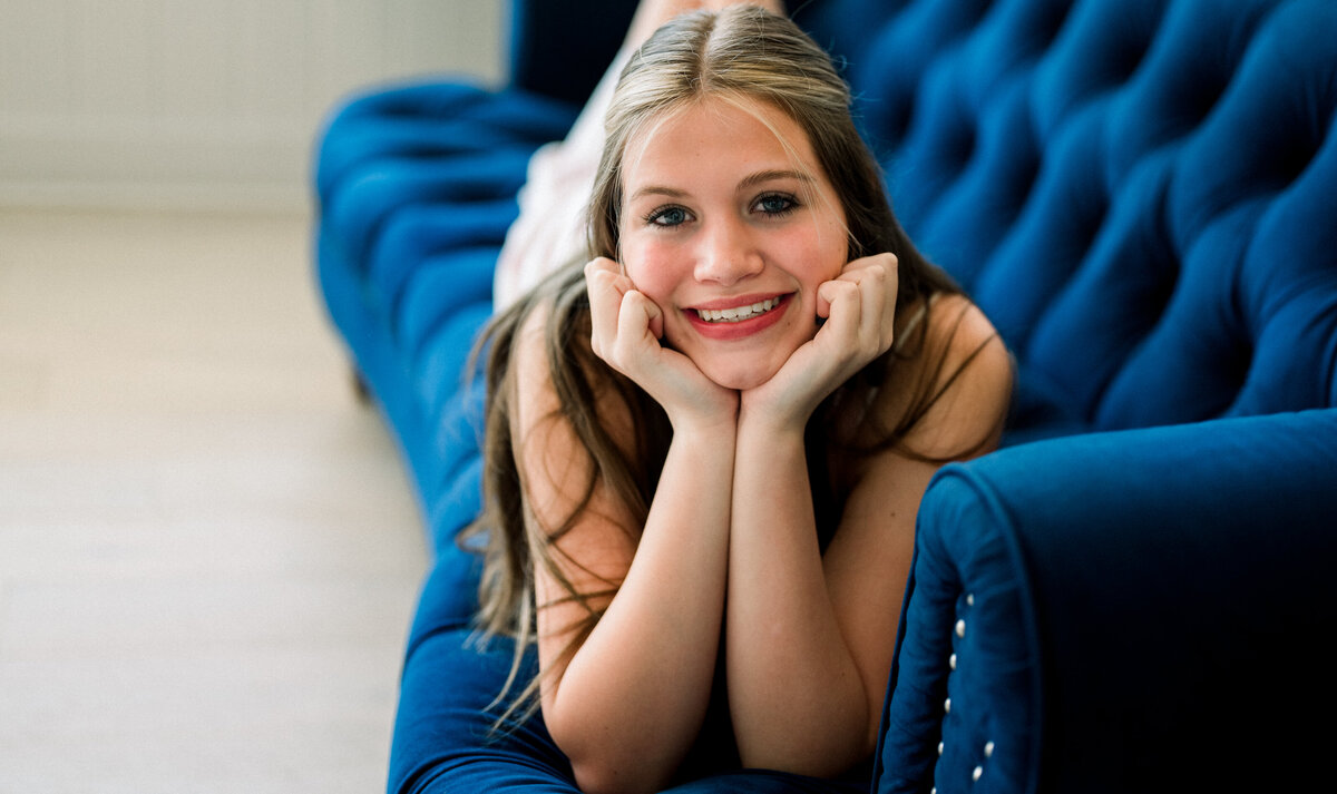 Teen girl on sofa, captured in a cute candid moment during a portrait session. By Photography by LV Hughes. Serving Bainbridge, Tallahassee, and surrounding areas. 