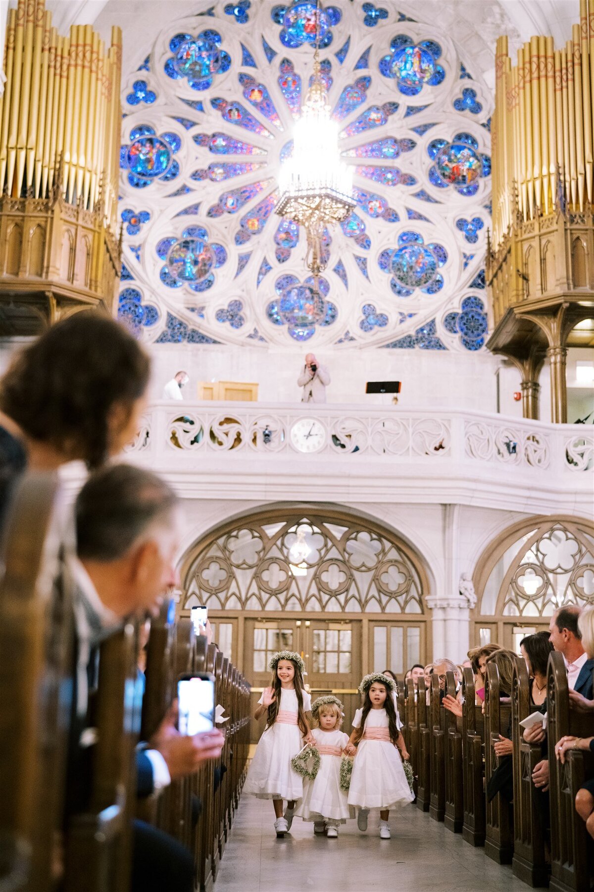 A picture of flower girls walking down the aisle during the ceremony. 