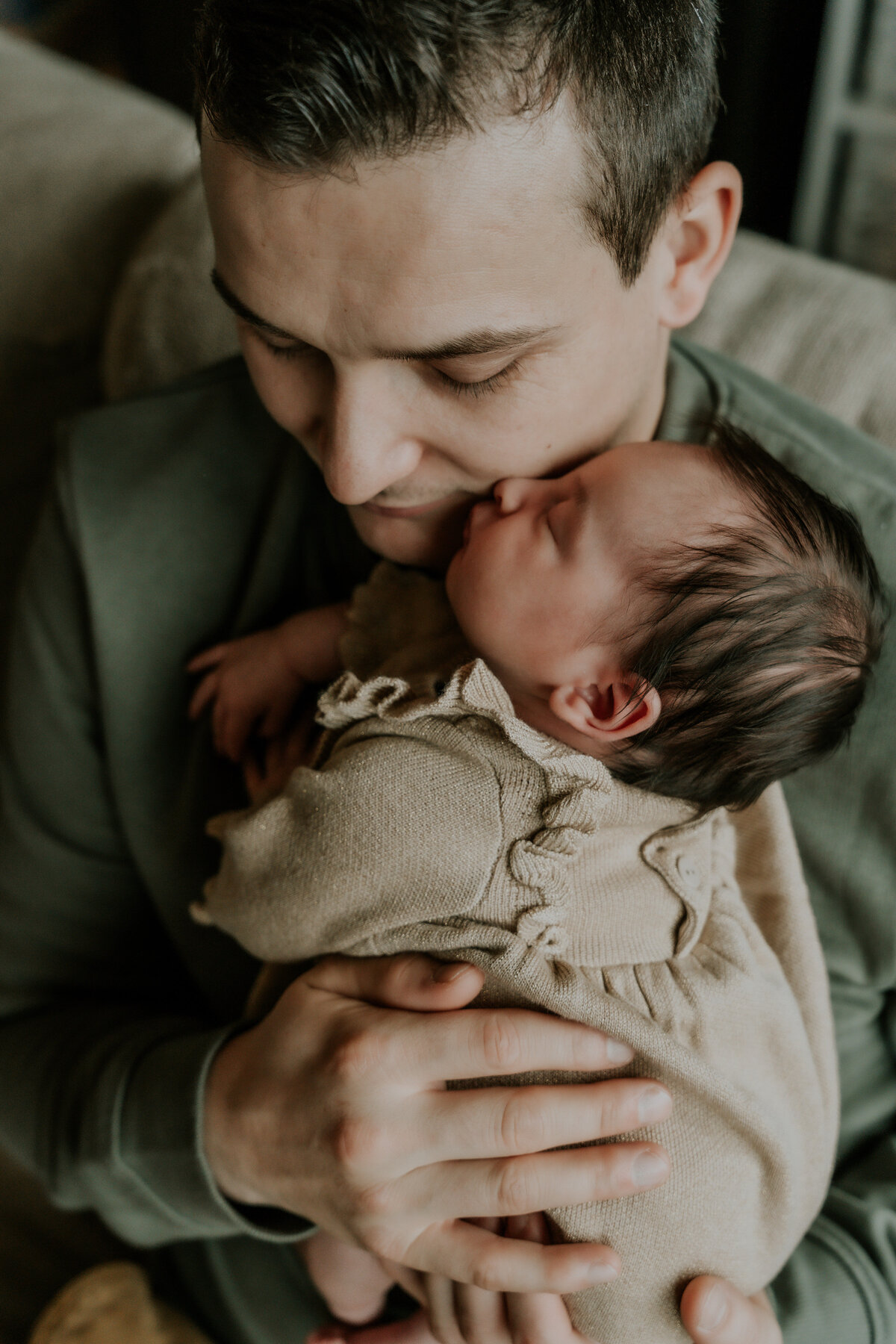 Knuffelmoment met de papa tijdens haar newbornshoot aan huis te Deurne.