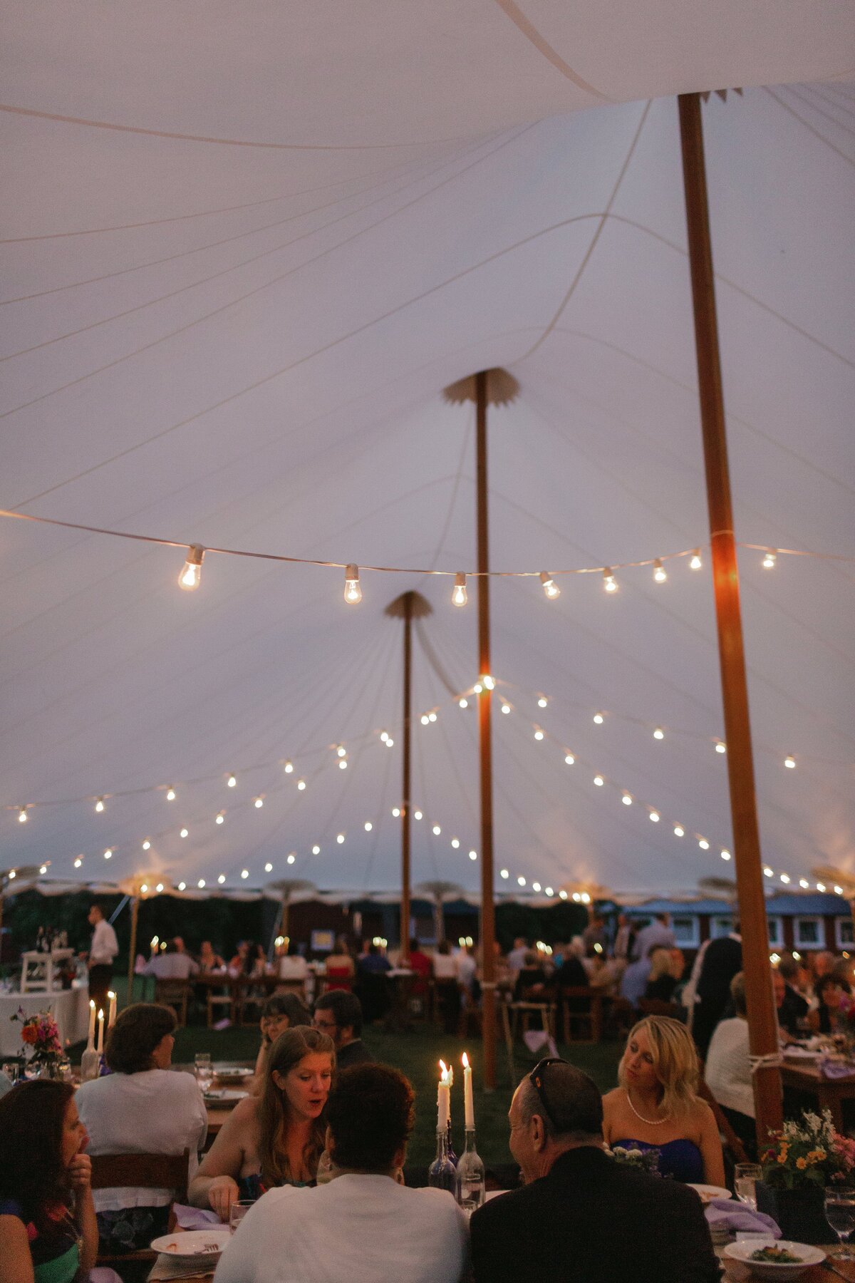 Candles illuminate a sperry tent during wedding reception in Vermont.