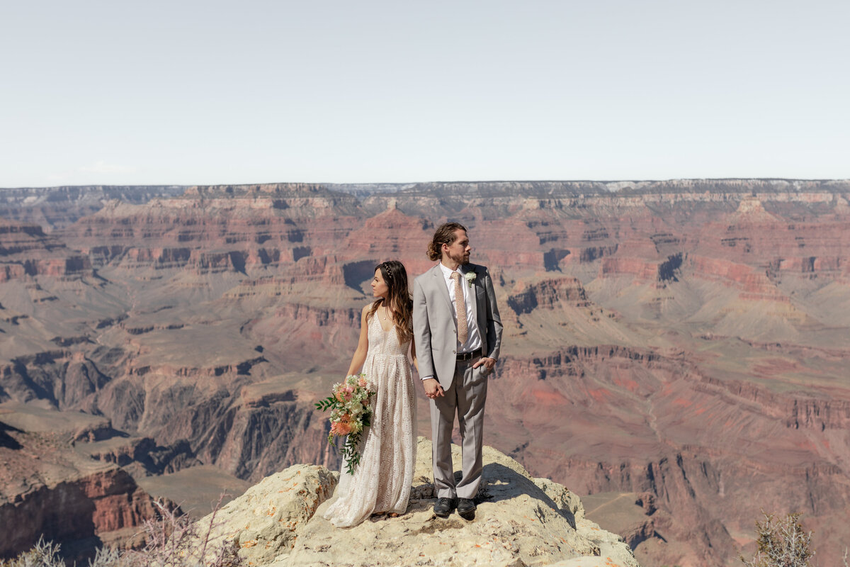bride and groom standing on top of mountain