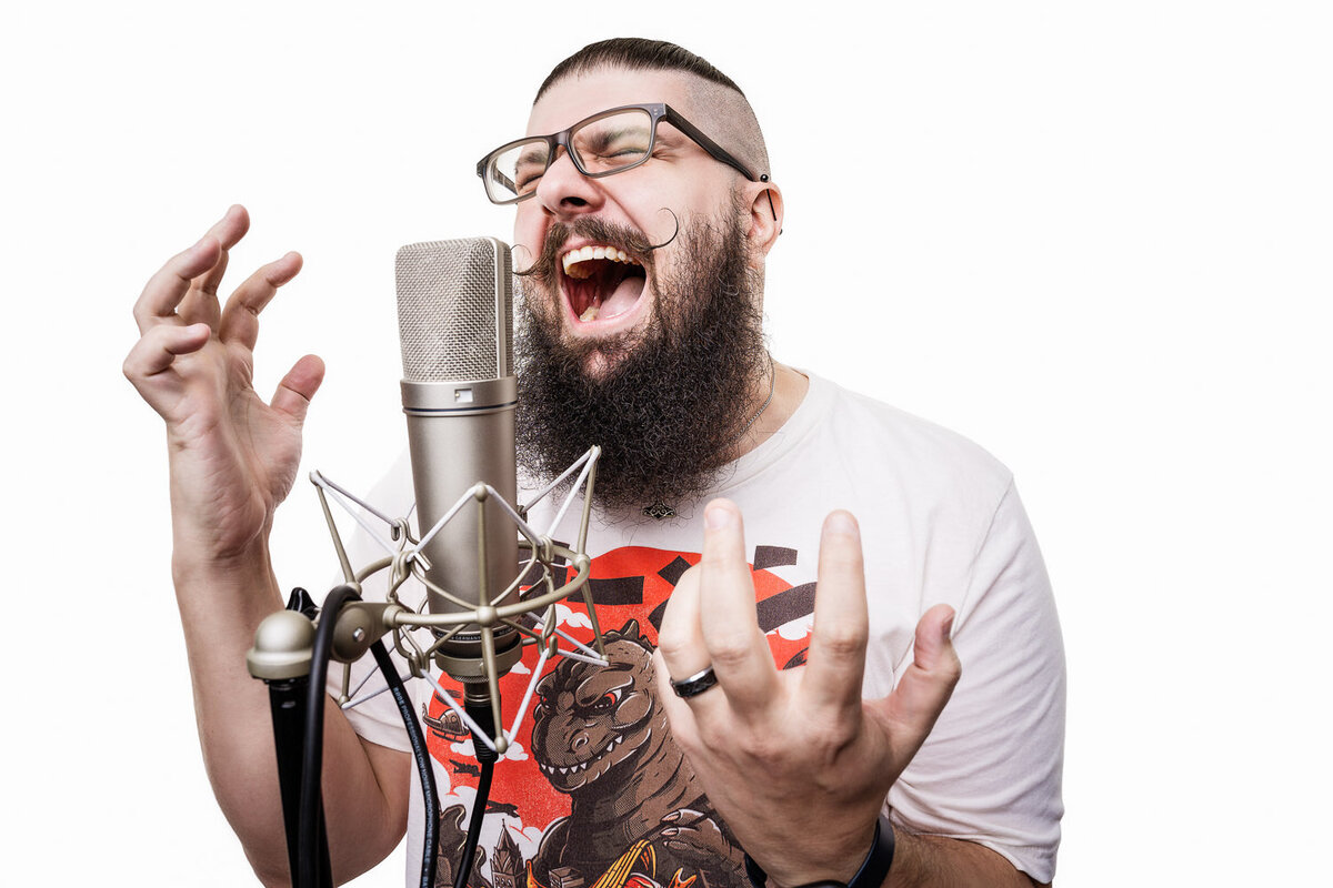 Personal branding image of a voice actor mid-performance in front of a microphone, photographed in Austin, TX.
