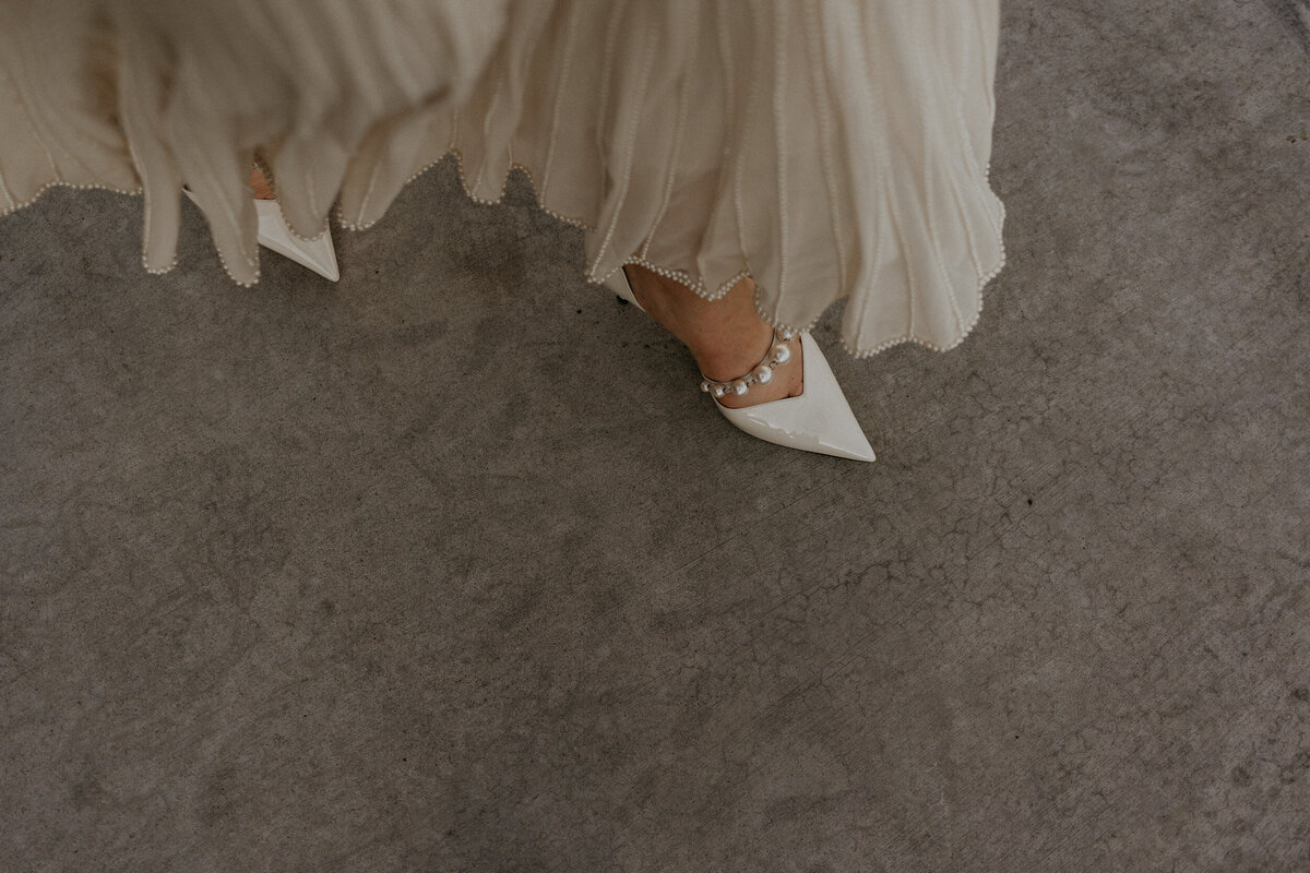 close up of brides vintage peal kitten heels and flowing dress